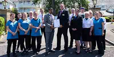 Davesh Kumar and Hawthorns Clevedon staff with Hospitality Assured Award